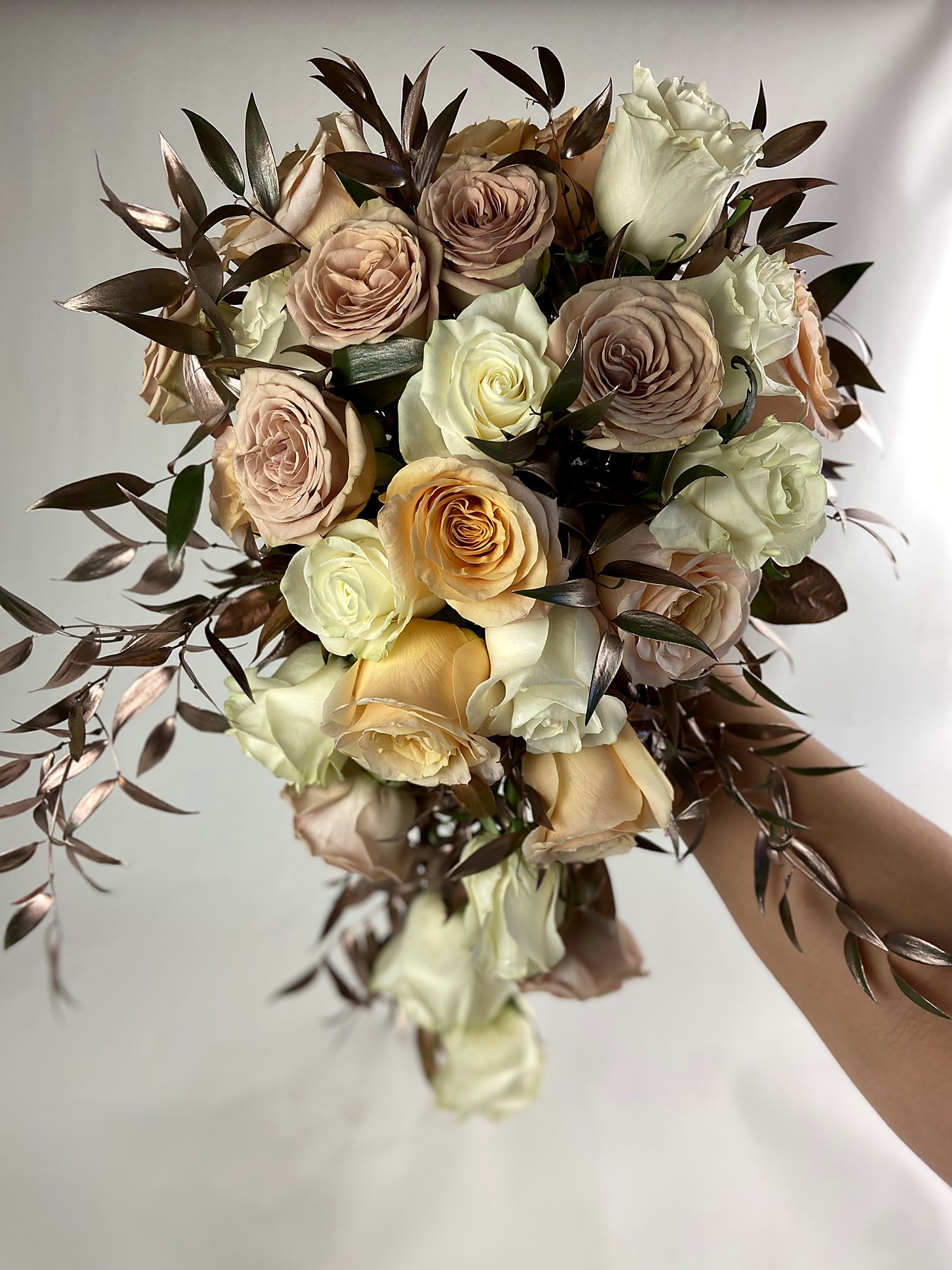 Cascading champagne and mauve bouquet with metallic foliage