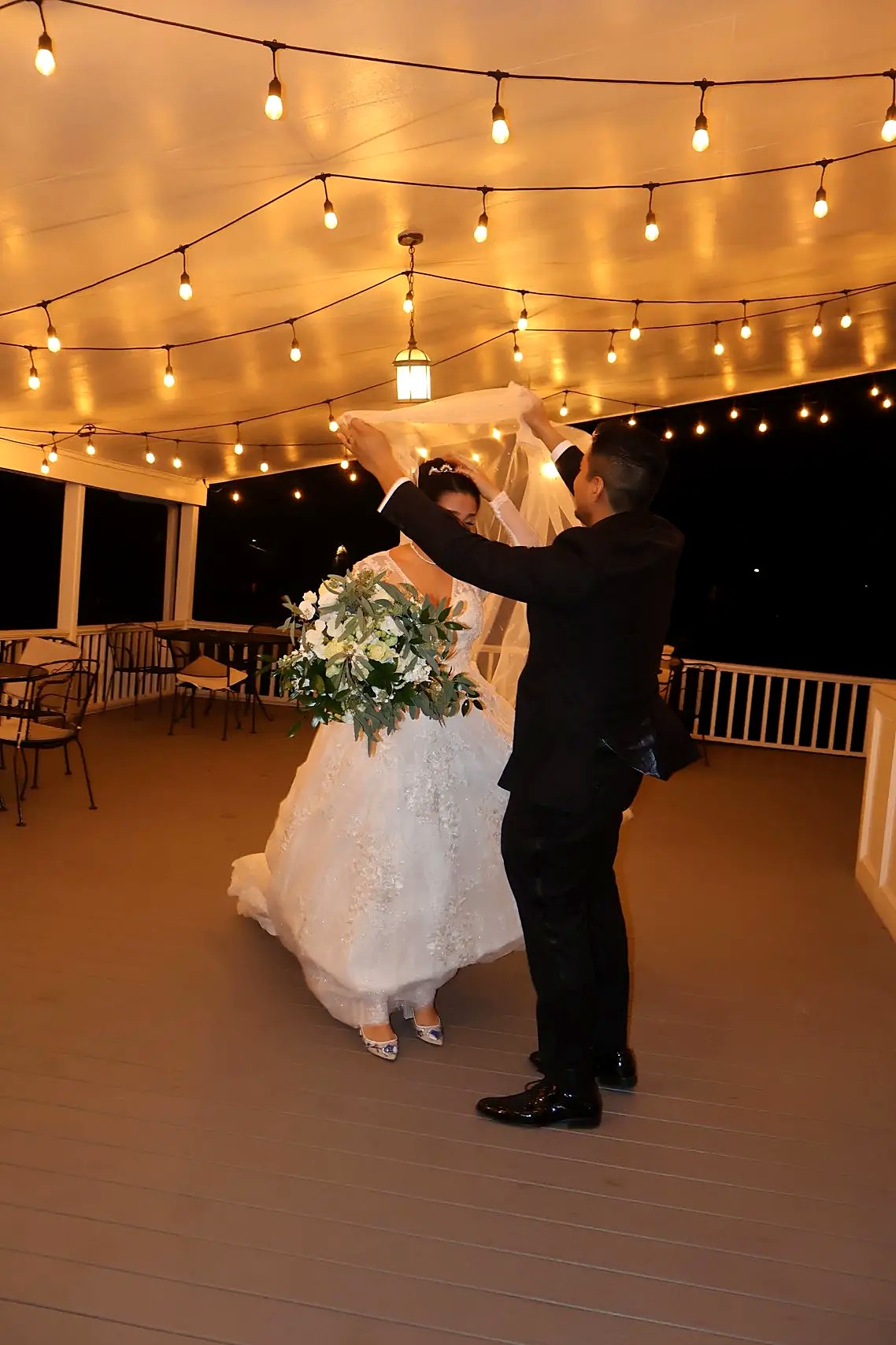 Bride and groom sharing a first dance under string lights