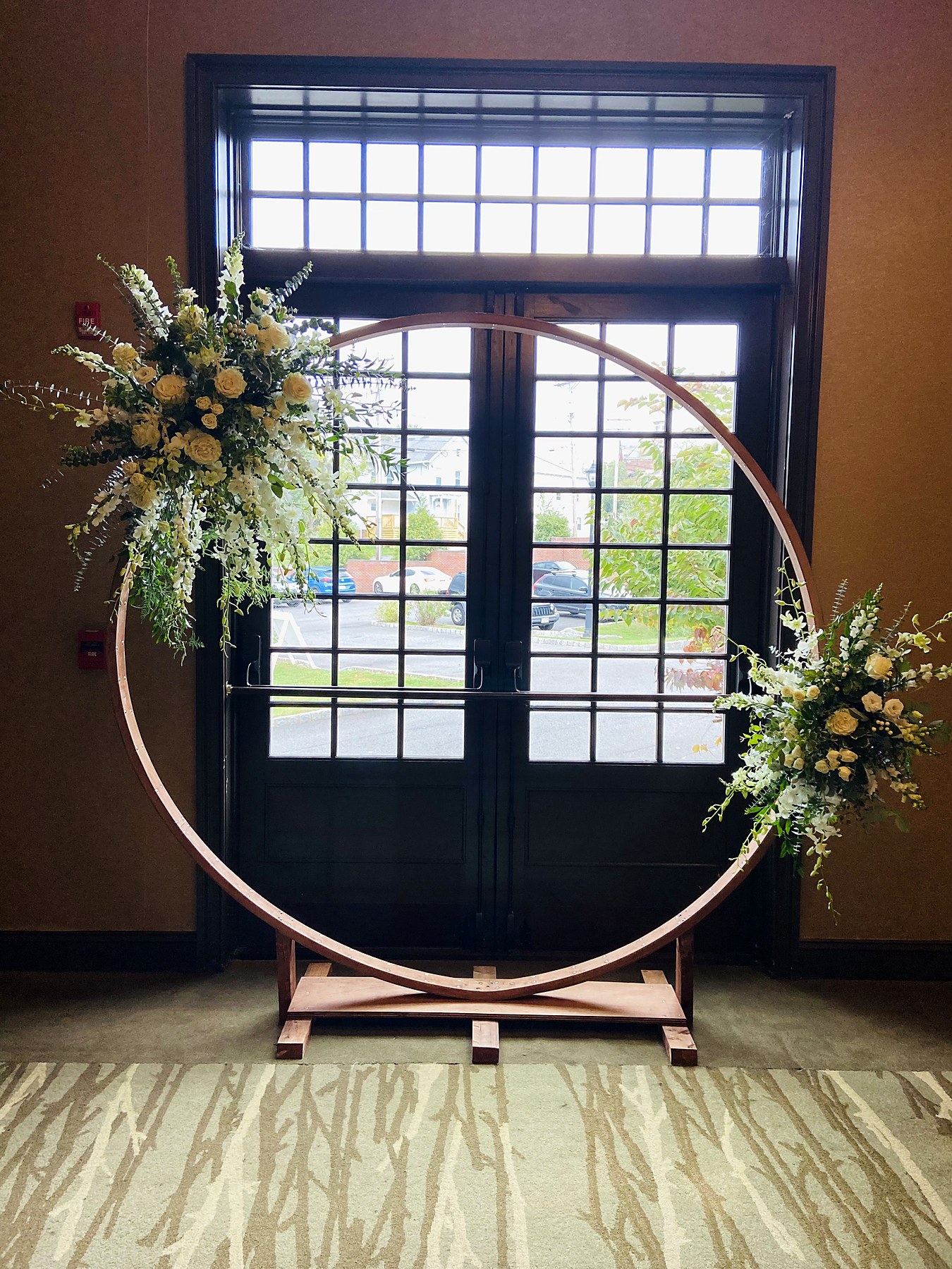 Circular floral arch with ivory roses and greenery